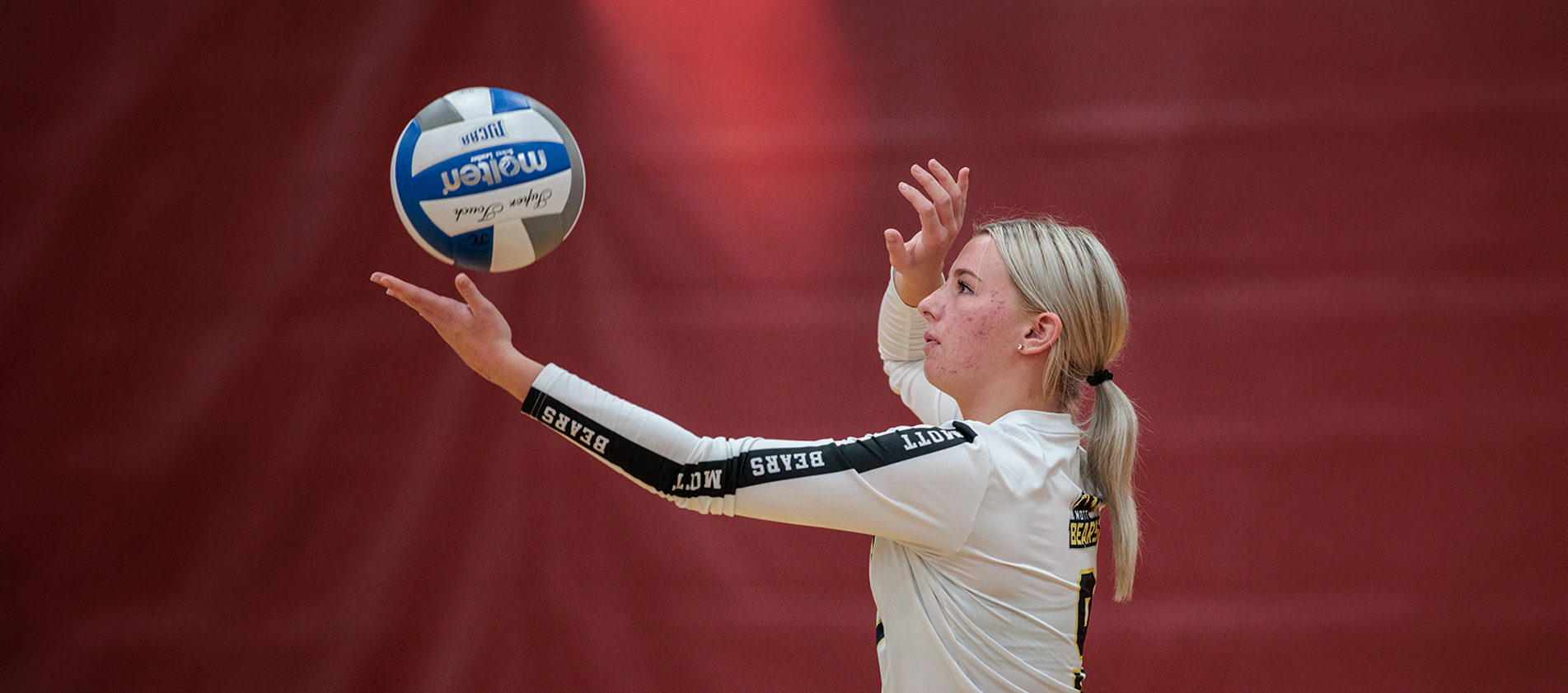 female volleyball player getting ready to serve the ball.
